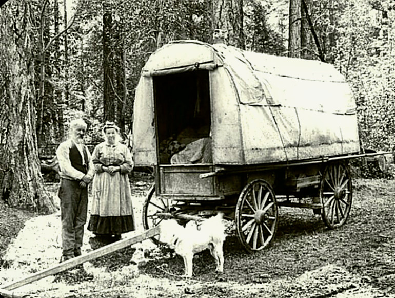 Oregon pioneers standing by their wagon