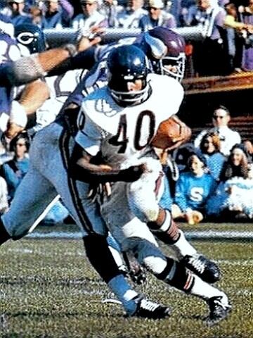 Gale Sayers leaving another would-be tackler with just air
