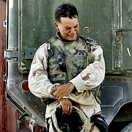 A soldier weeps by his vehicle in Iraq
