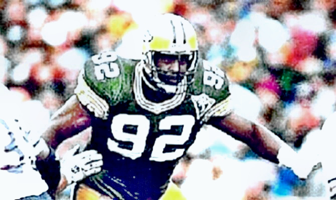 Reggie White as a Packer throwing blockers away